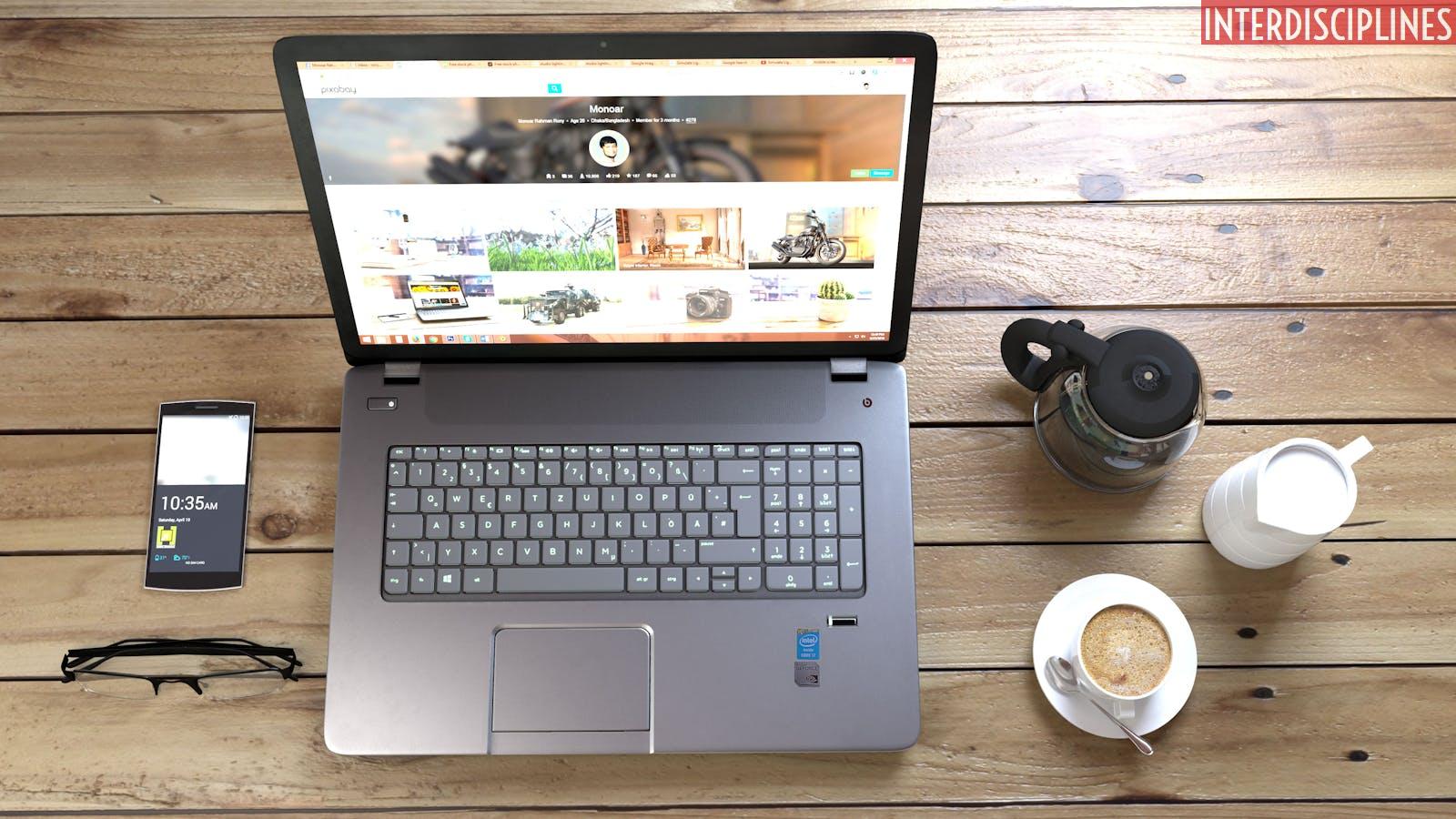 Silver Laptop Next to Coffe Cup Smartphone and Glasses