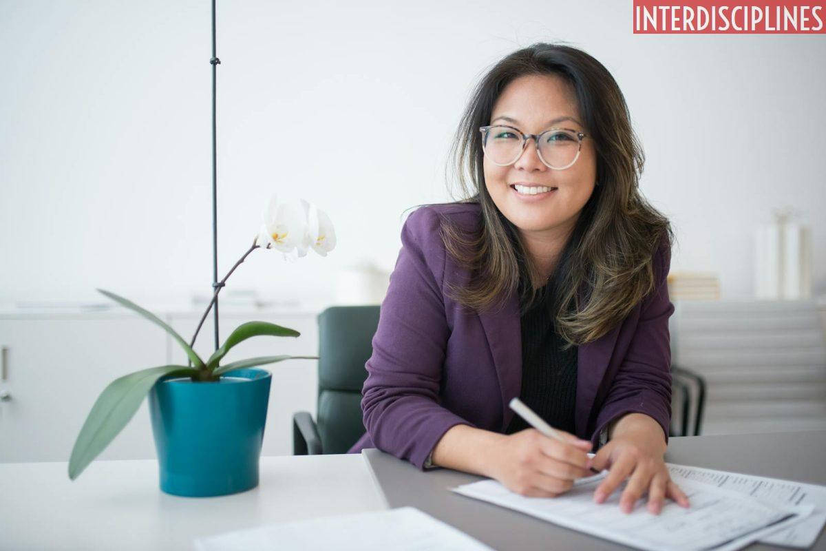 A Woman Sitting on a Table with Potted Plant
