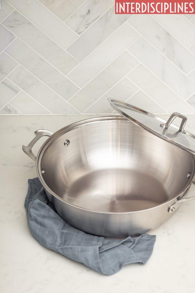 stainless steel cooking pot on blue denim jeans