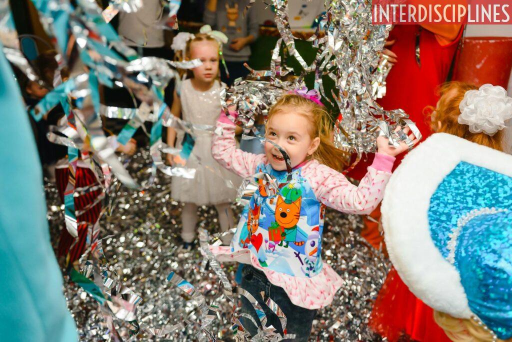 Joyful children having fun at an indoor party, with colorful streamers adding to the festive atmosphere.