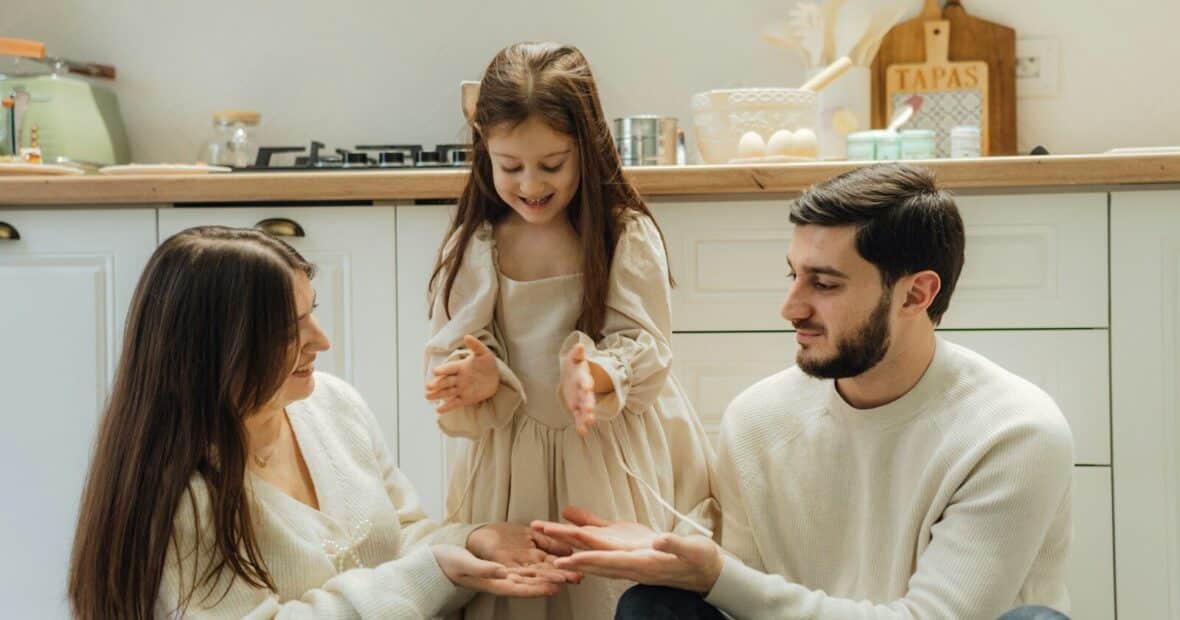 Disciplina positiva en familia: madre, padre e hija conversan con calma en la cocina