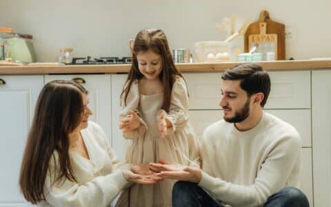 Disciplina positiva en familia: madre, padre e hija conversan con calma en la cocina